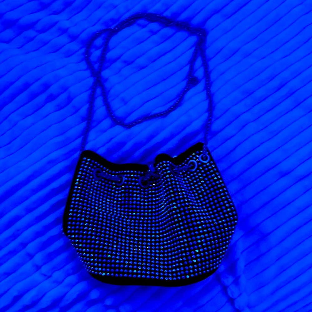 Black purse with gems on the outside, pearl detail on the strap.